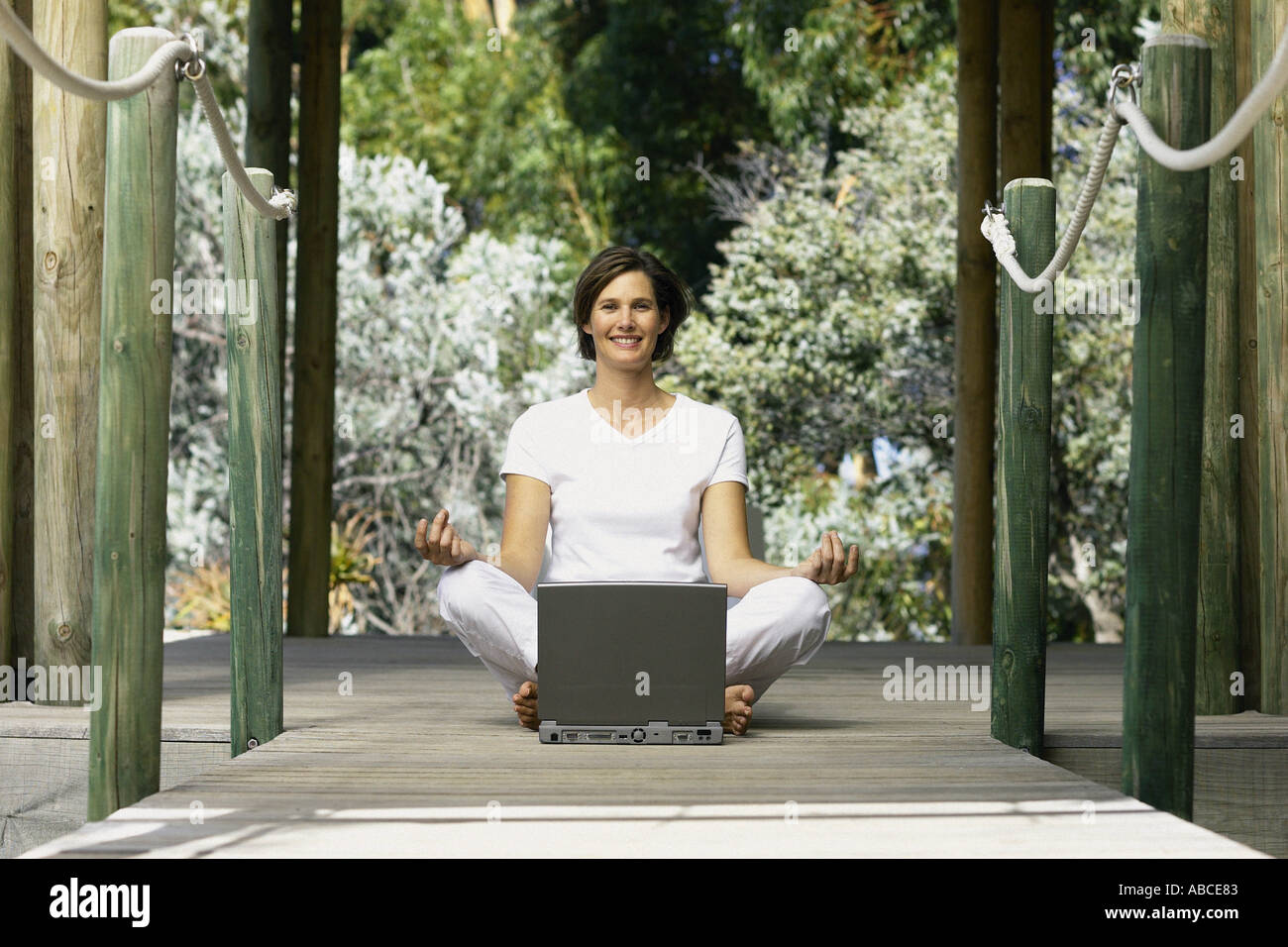 Woman with computer doing yoga Stock Photo