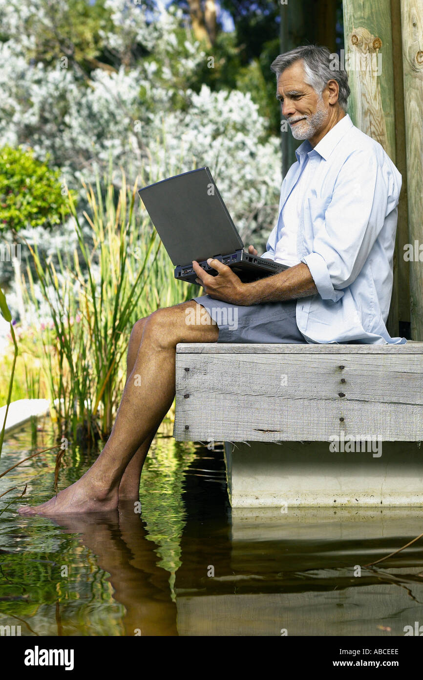 Man beside pool with computer Stock Photo - Alamy