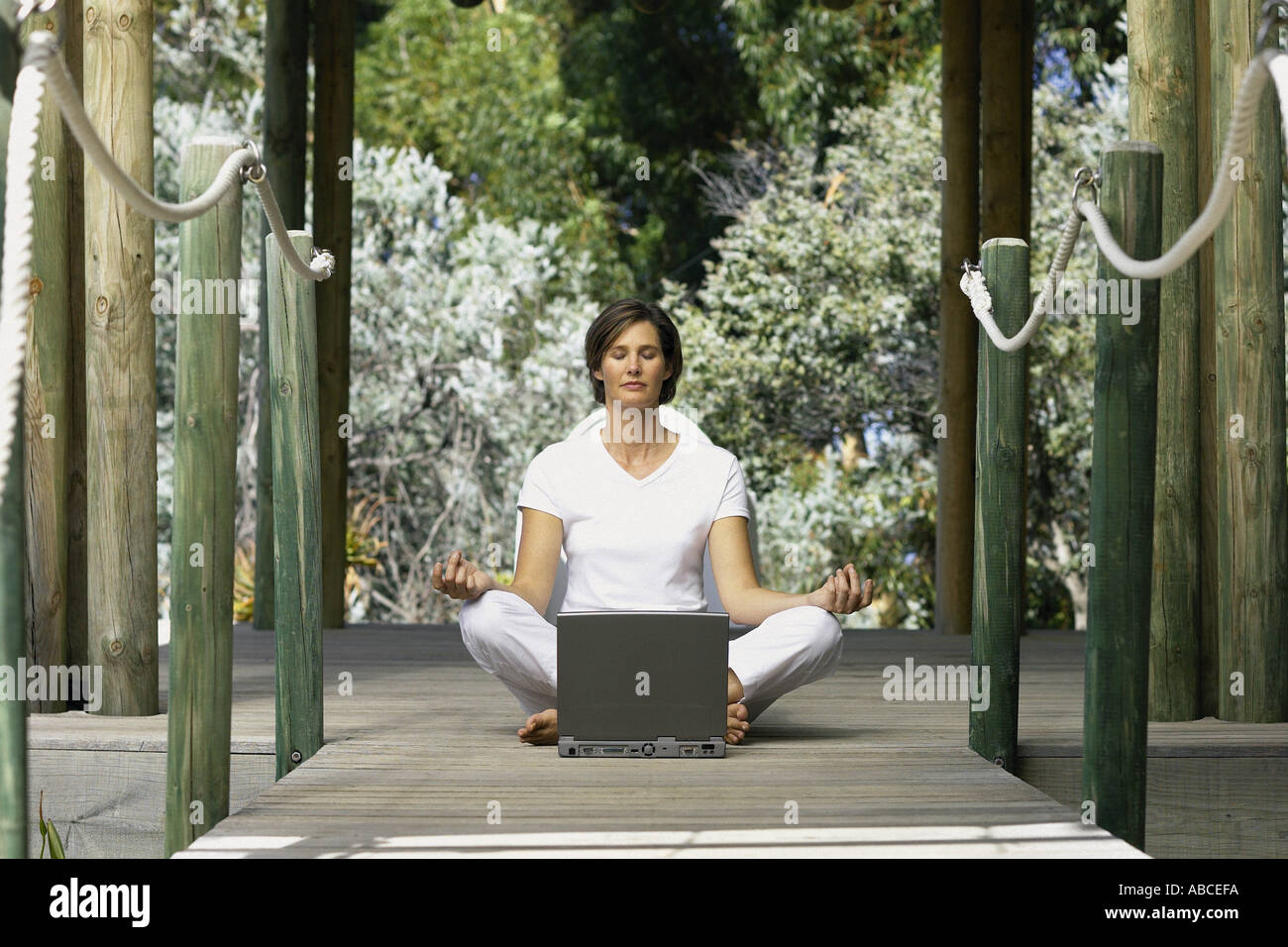 Woman with computer doing yoga Stock Photo