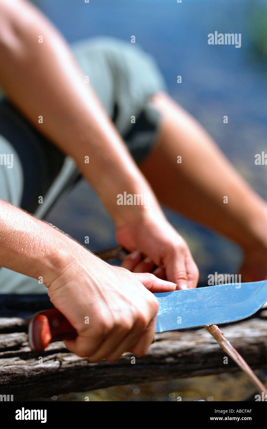Man cutting a wooden stick Stock Photo