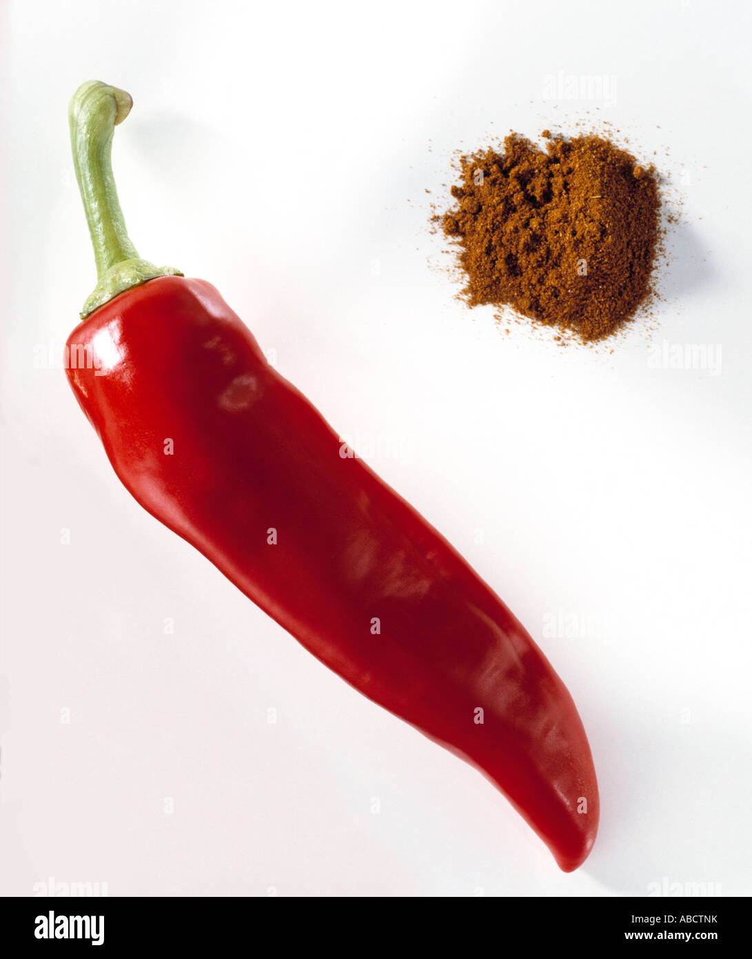 Fresh red chilli and pile of chilli powder on white background Stock Photo