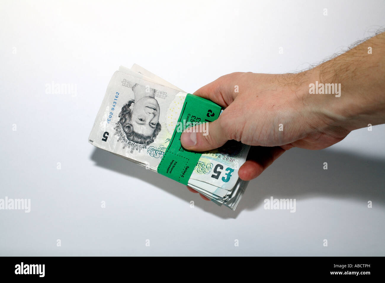Man with bundle of five pound notes Stock Photo