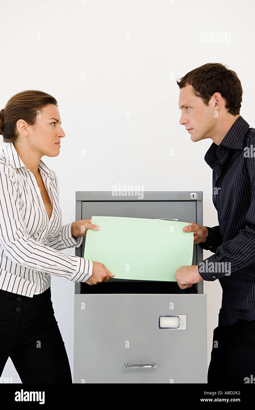 Businessman and businesswoman fighting over file Stock Photo