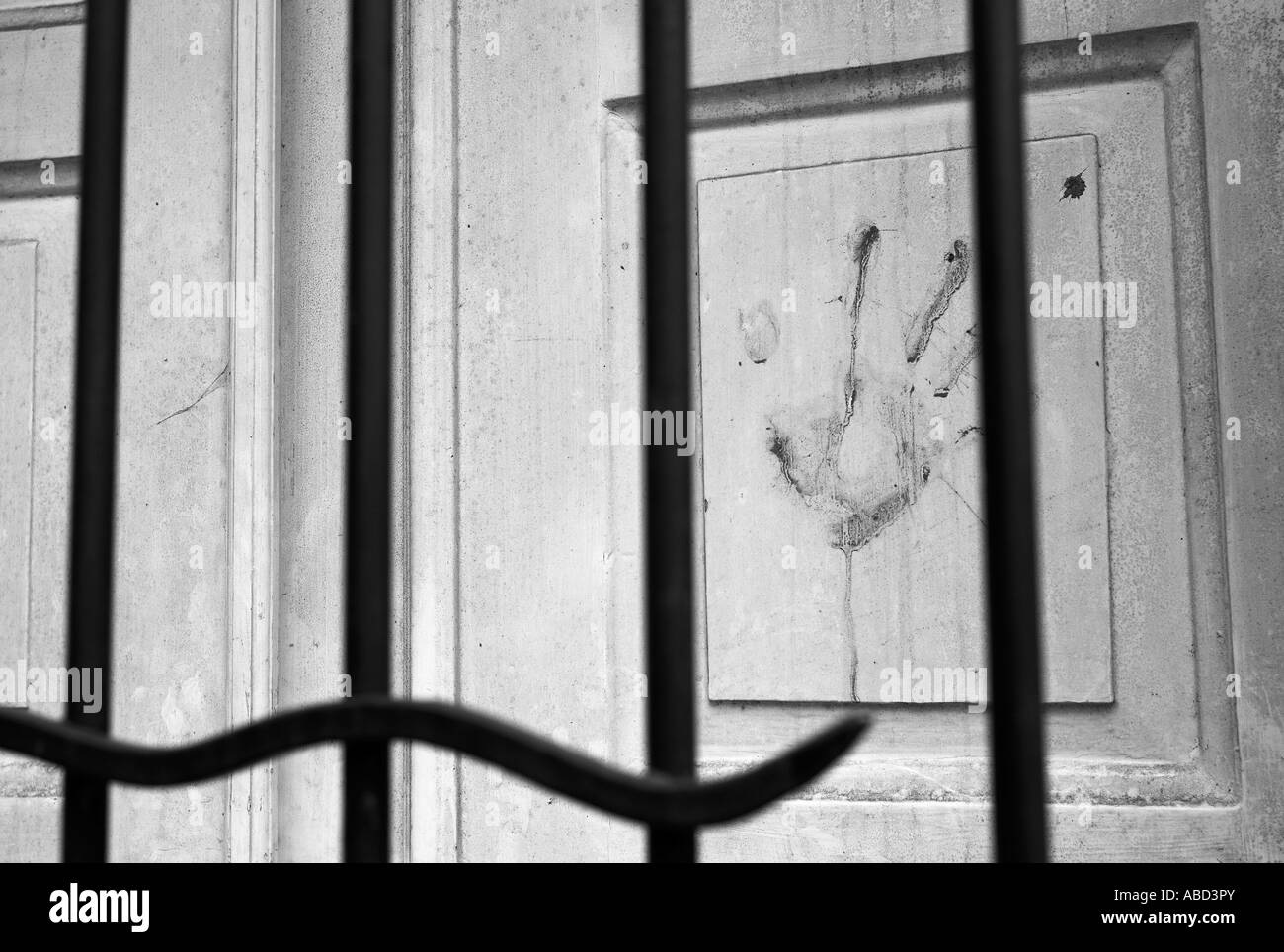 A hand print on a door behind a gate Stock Photo