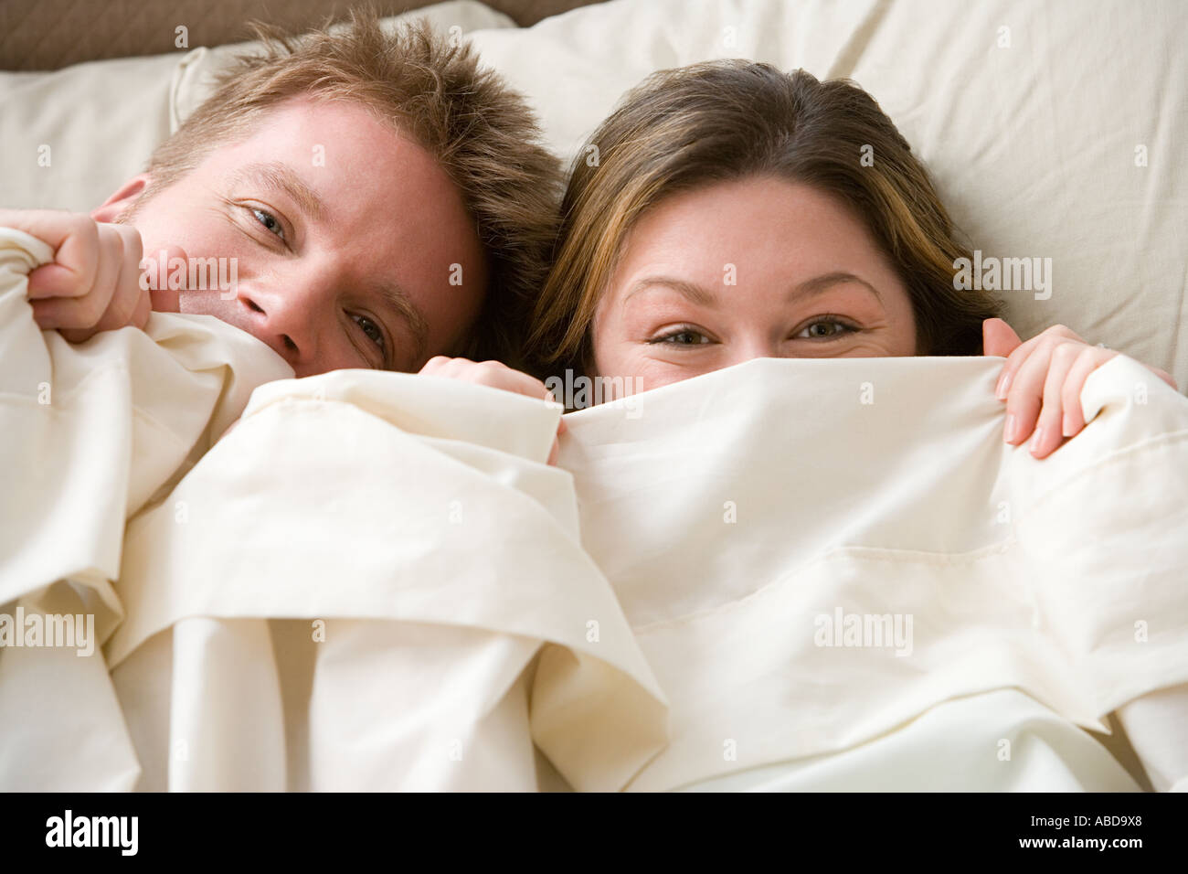 Couple hiding under sheet Stock Photo Alamy