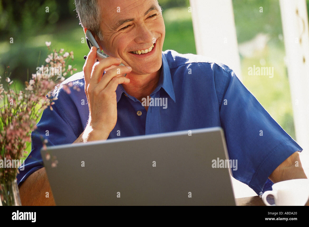 Man using laptop computer and cellphone Stock Photo