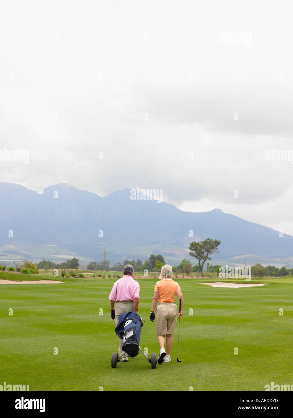 Couple walking on golf course Stock Photo