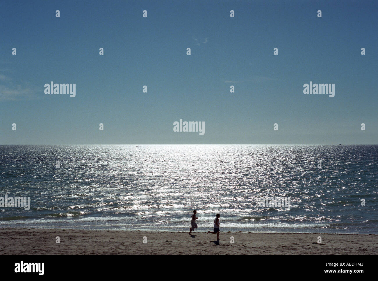 Two young men running on beach Stock Photo