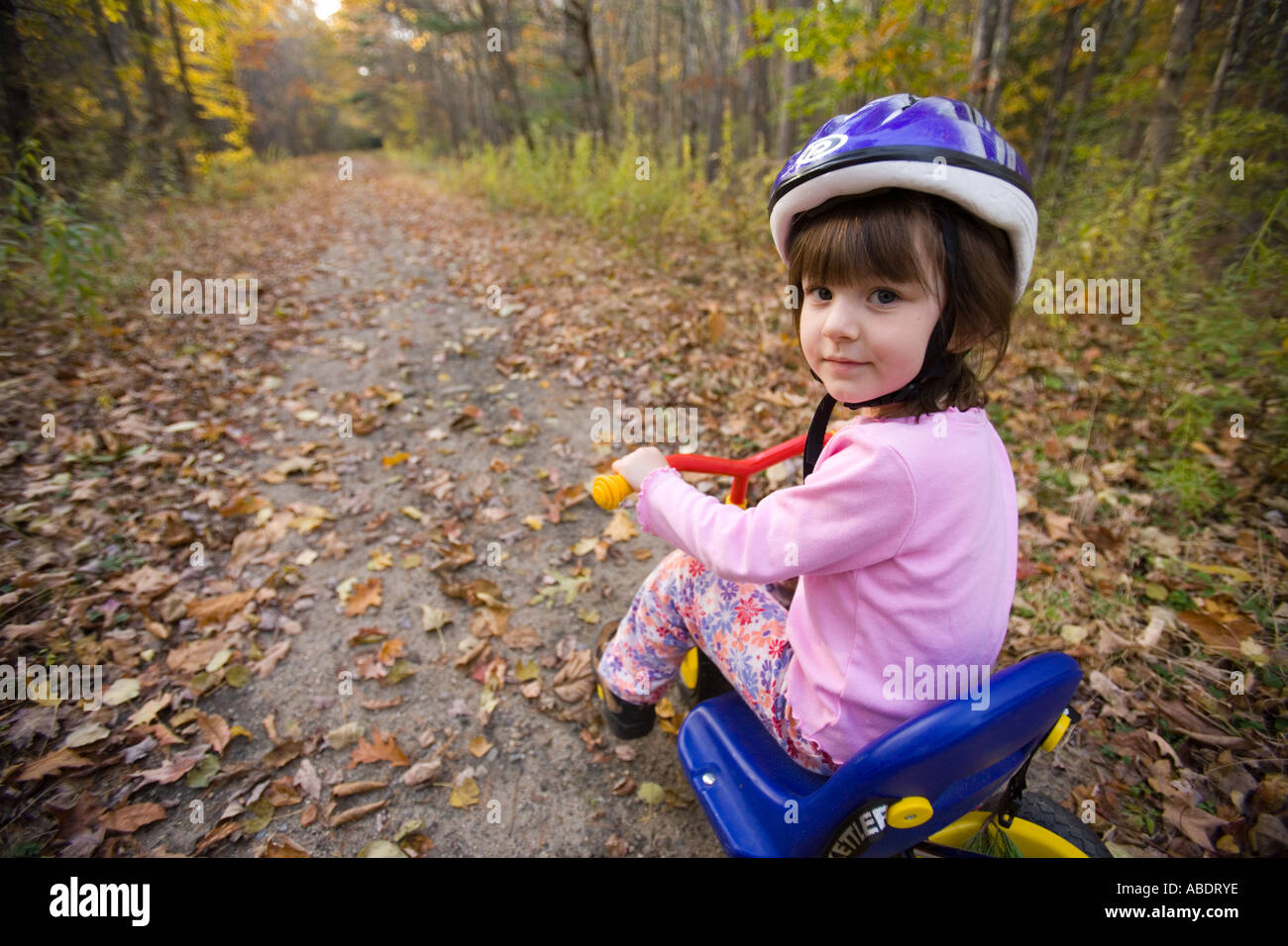 A young girl age 4 on her bike Newfields rail trail in Newfields NH Fall Stock Photo