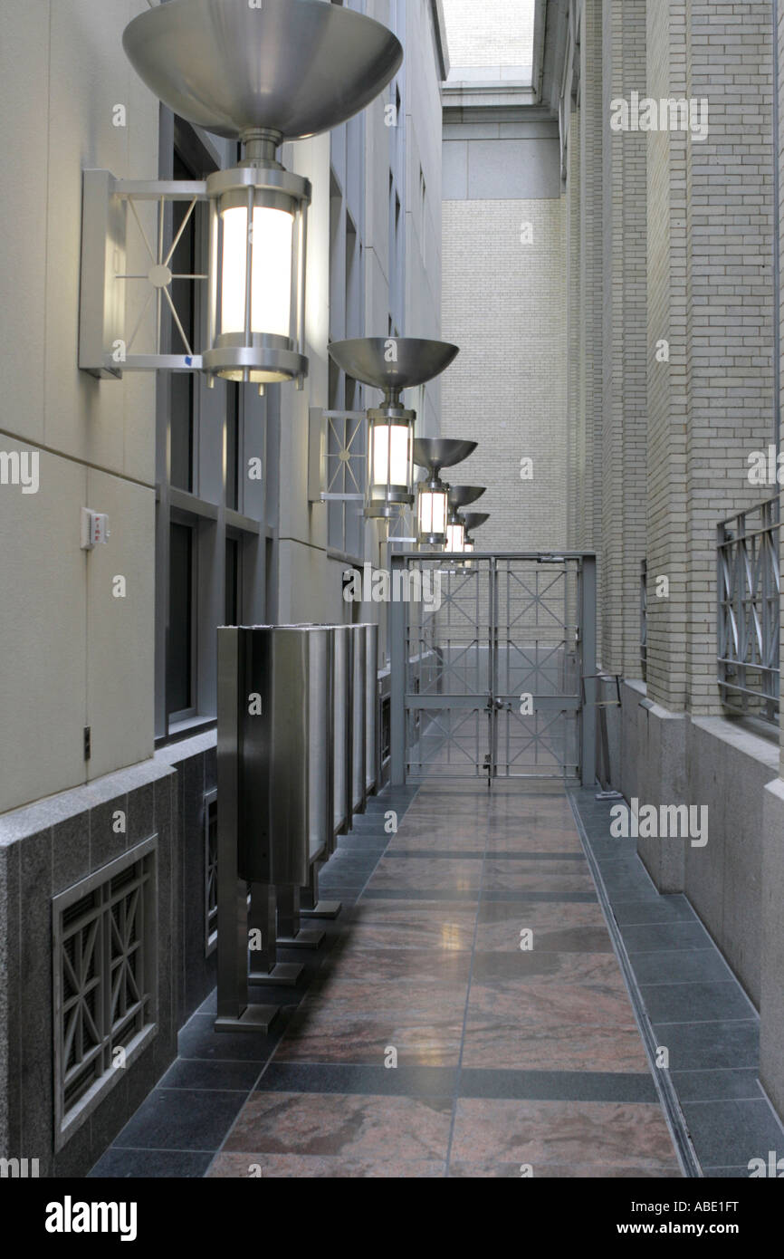 Long Hallway with Multiple Light Fixtures Mounted on Wall and with Gate