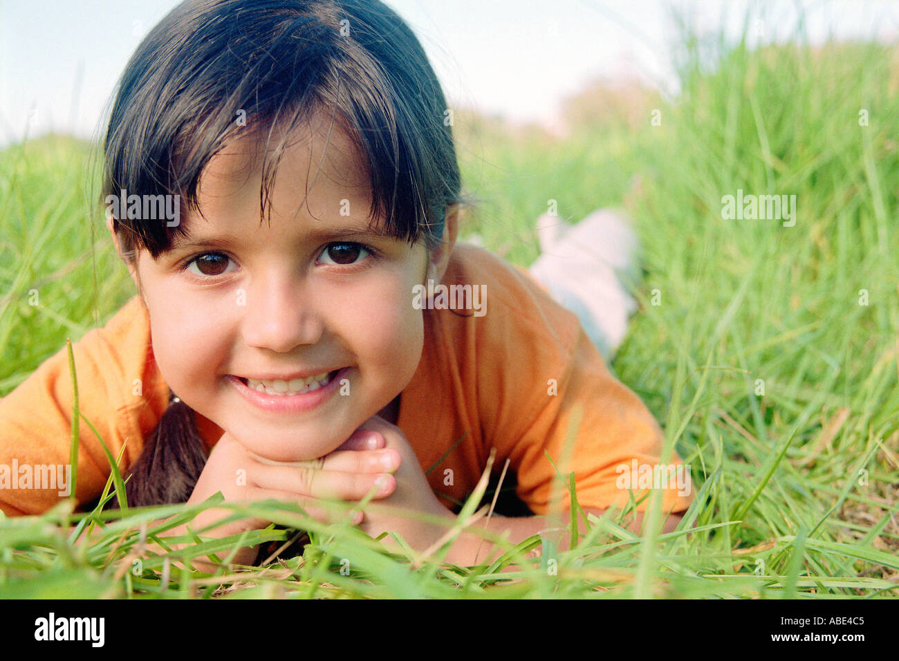 Smiling girl lying on grass Stock Photo Alamy