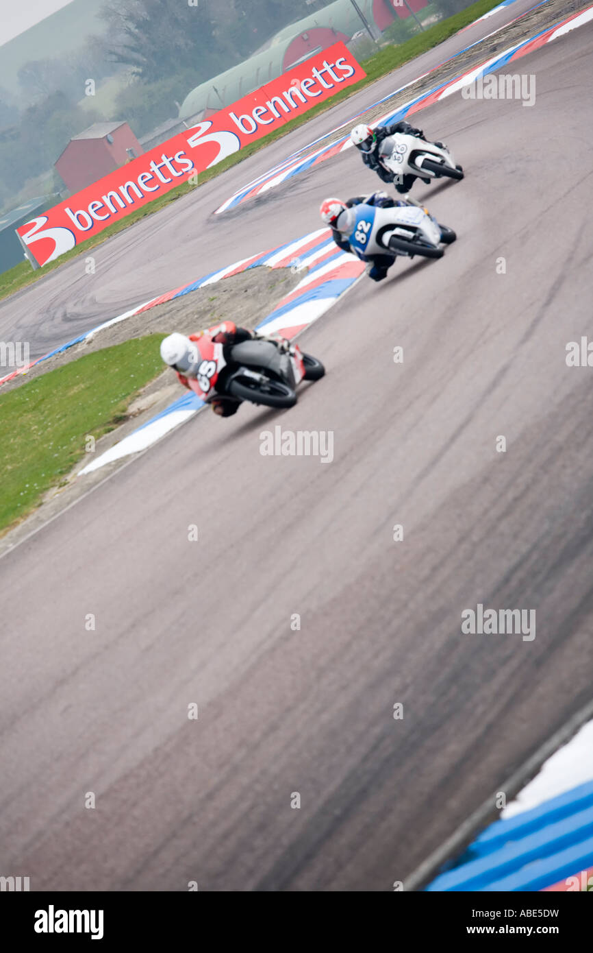 three racing motorbikes riders leaning into the bends and corners of the chicane Stock Photo