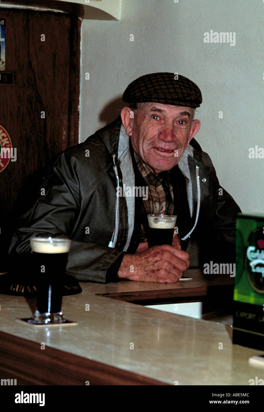 elderly man sits in an irish pub drinking his favourite drink Stock