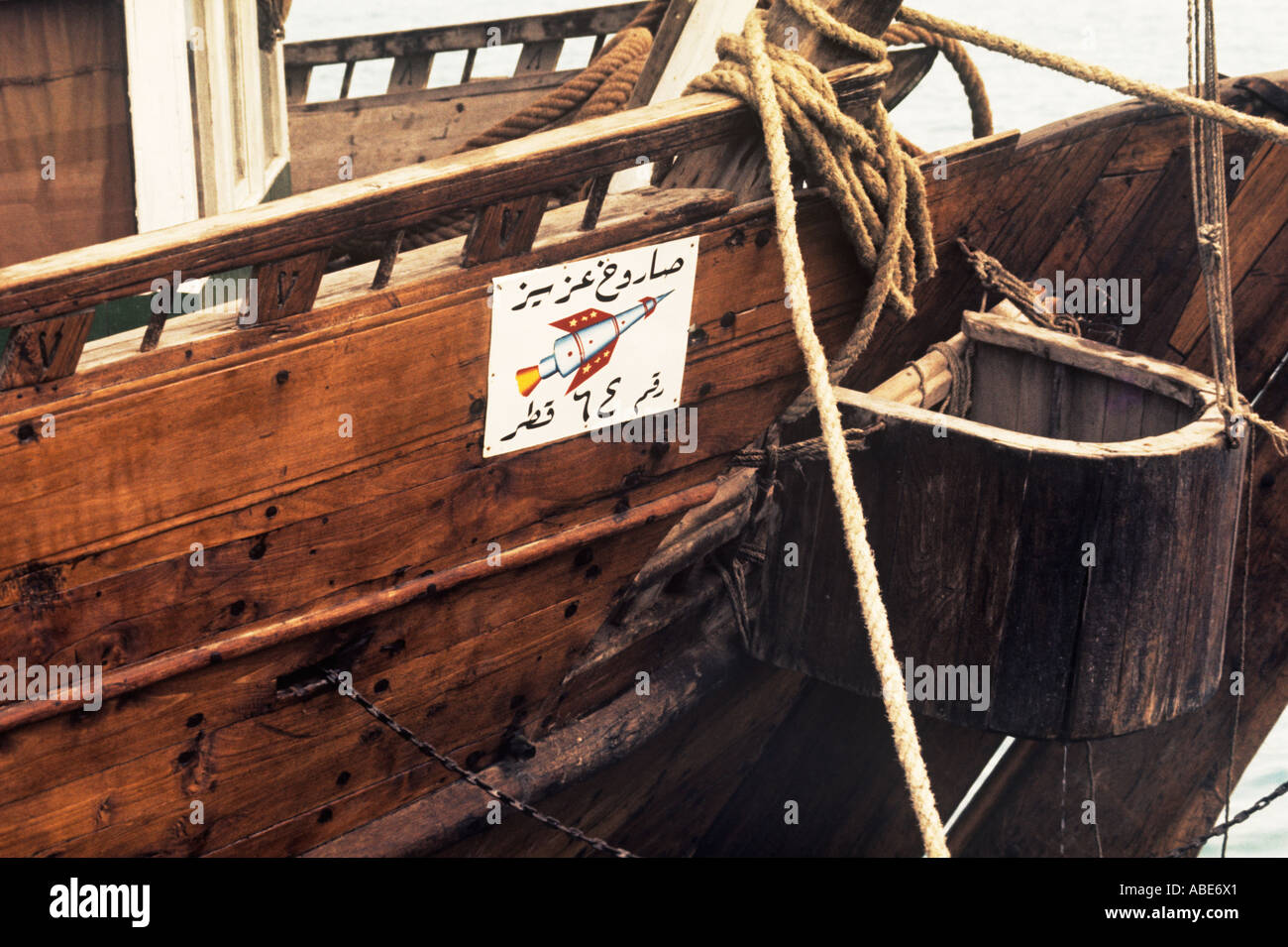 Next to the open zuli, or toilet box, a small Gulf dhow boasts its modernity with a rocket emblem Stock Photo