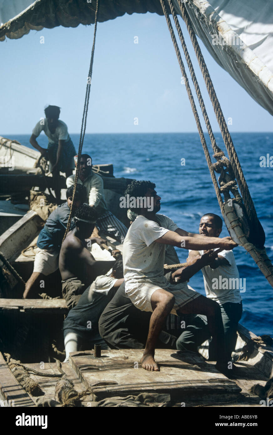 The crew of a big Arab dhow, an oceangoing 'boom', bring round the ship's great sail Stock Photo