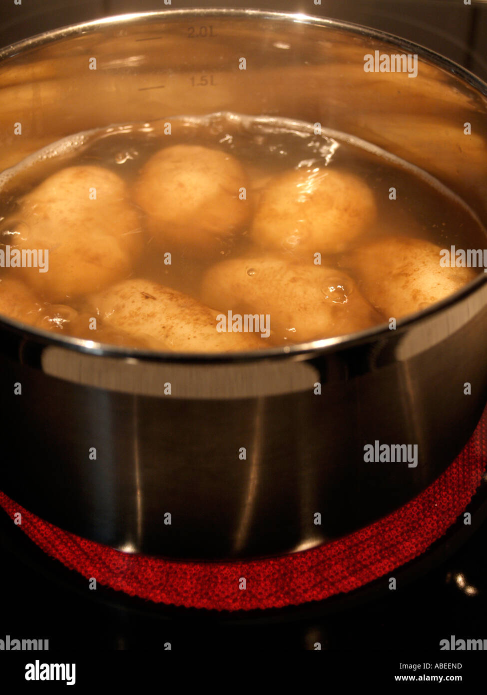 potatoes with skin cooking in water in a stailess steel pot on ceramic