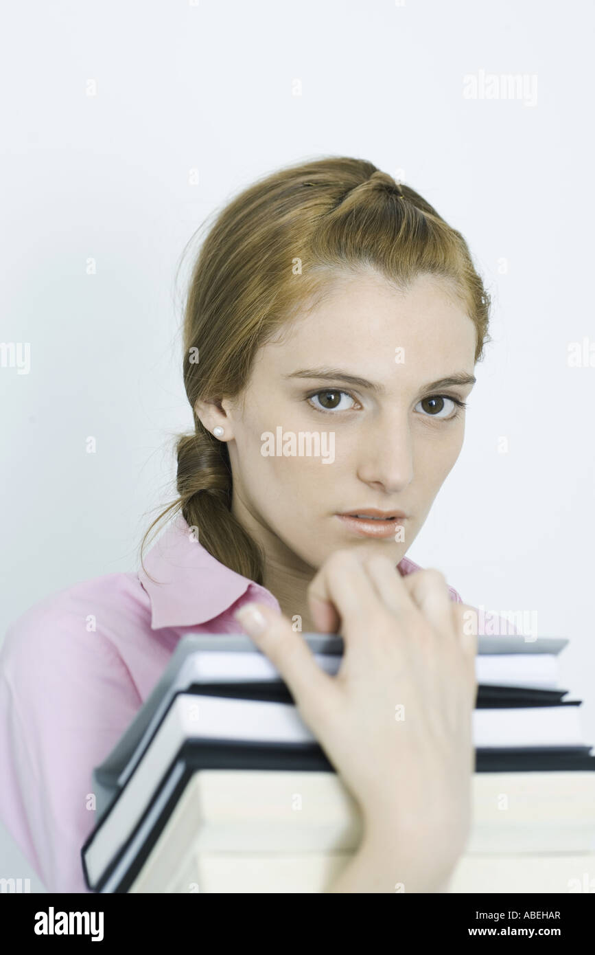 Teenage girl holding stack of books, portrait Stock Photo - Alamy