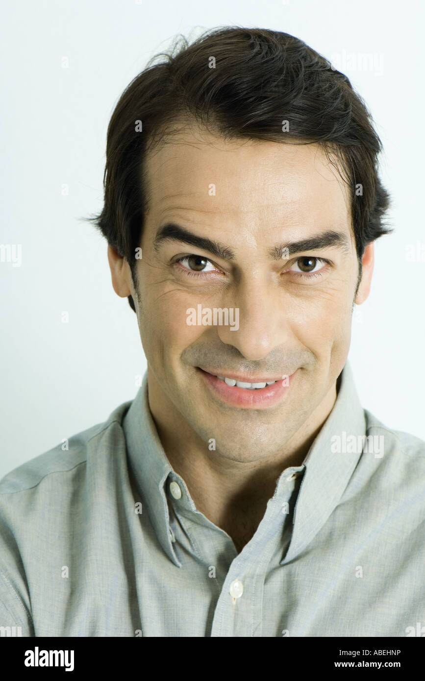 Man looking at camera, raising eyebrow, head and shoulders, portrait Stock Photo