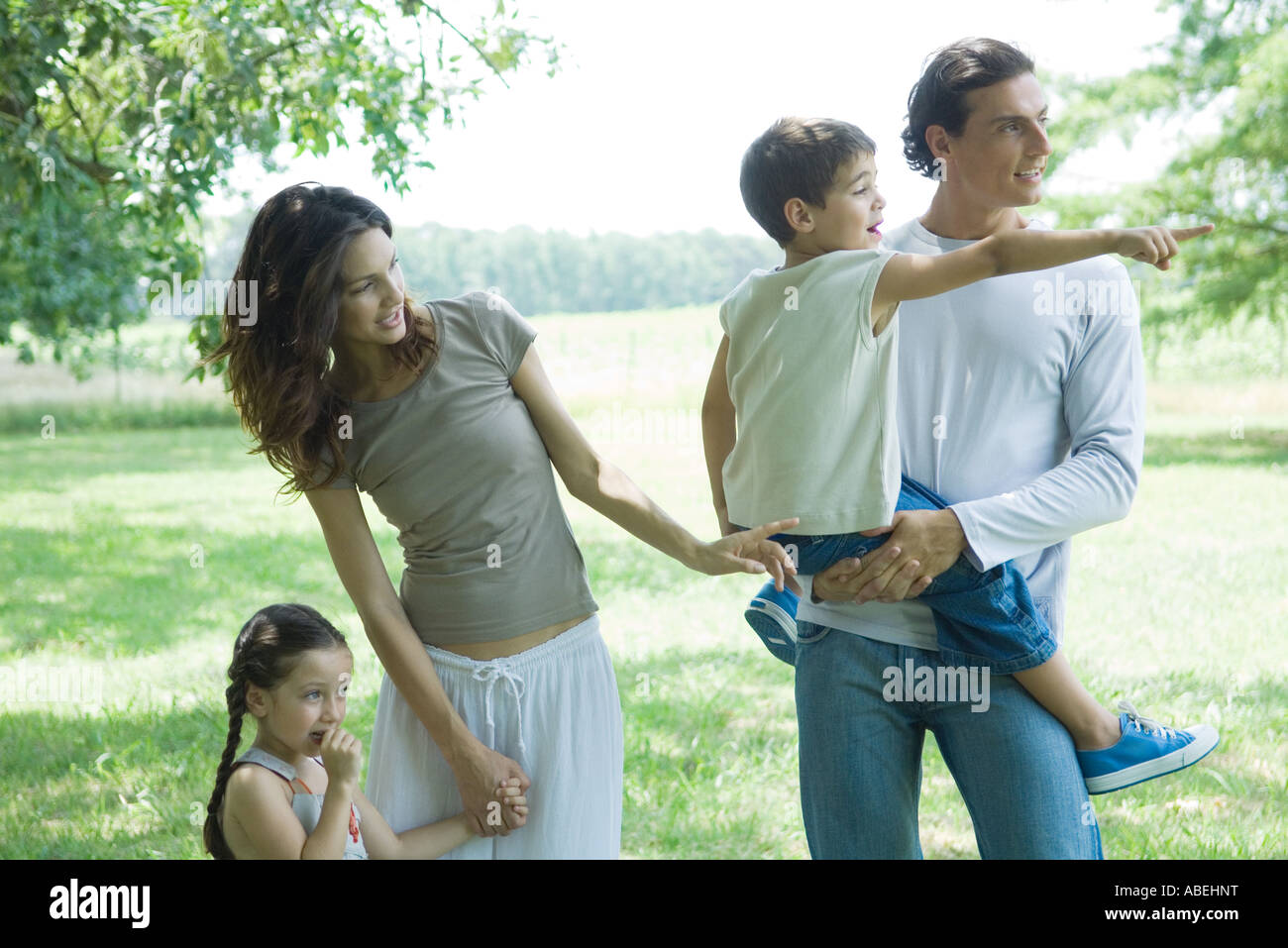 Family standing outdoors on lawn on a sunny day Stock Photo