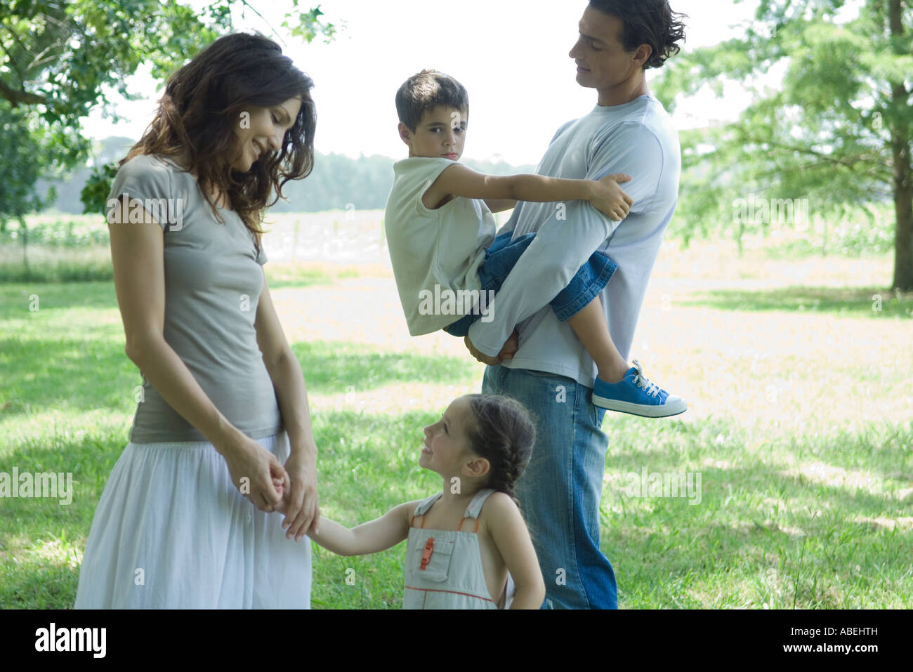 Family outdoors on a grassy lawn on a sunny day Stock Photo