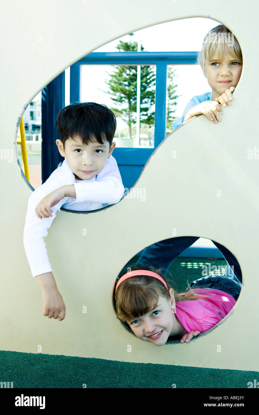 Children on playground equipment, smiling at camera Stock Photo