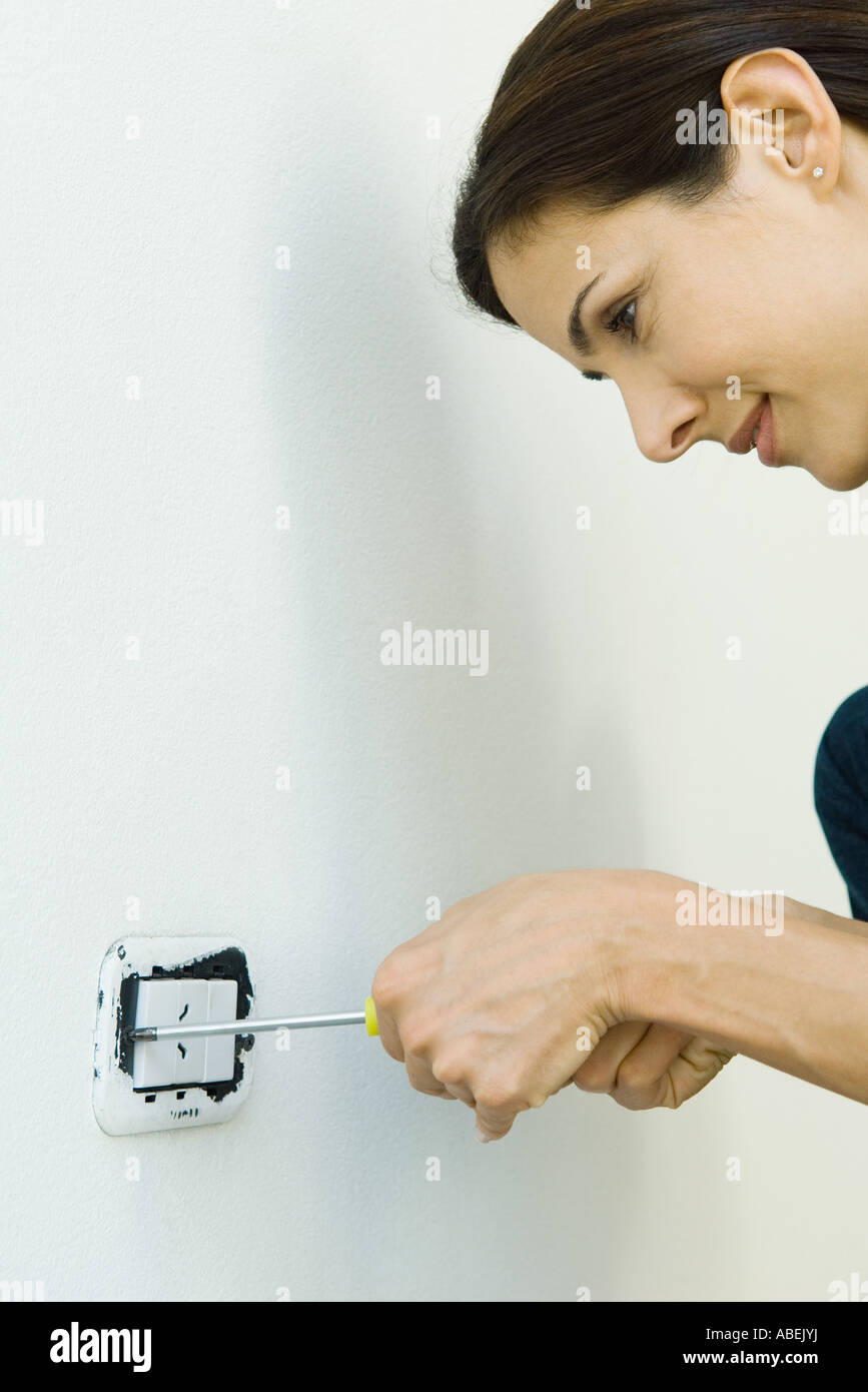 Woman removing lightswitch cover from wall Stock Photo Alamy