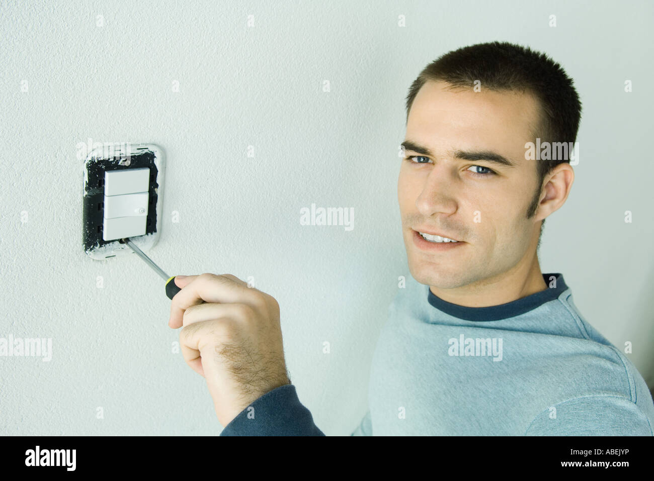 Man removing light switch cover from wall Stock Photo Alamy