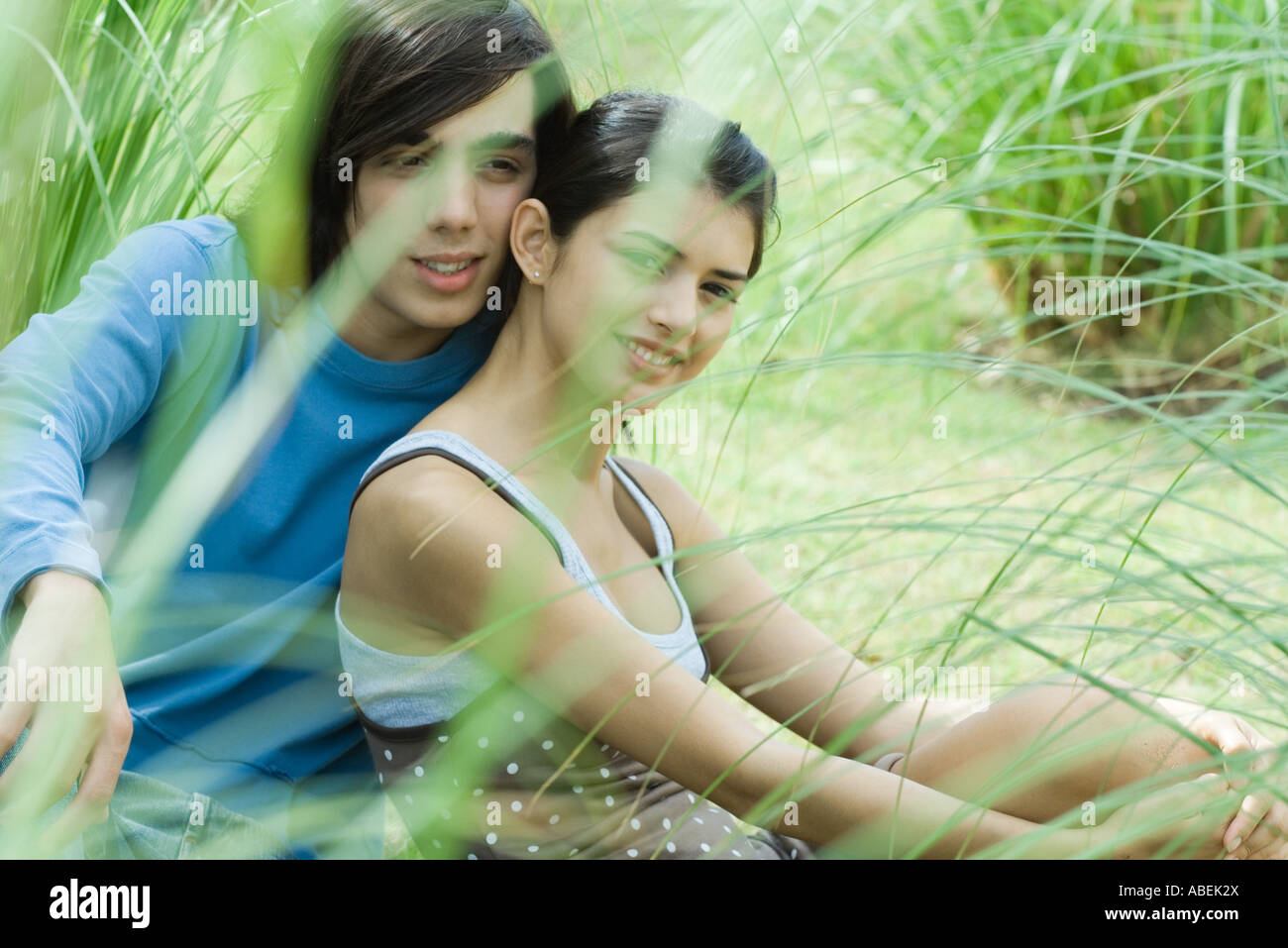 Young couple sitting on grass together Stock Photo