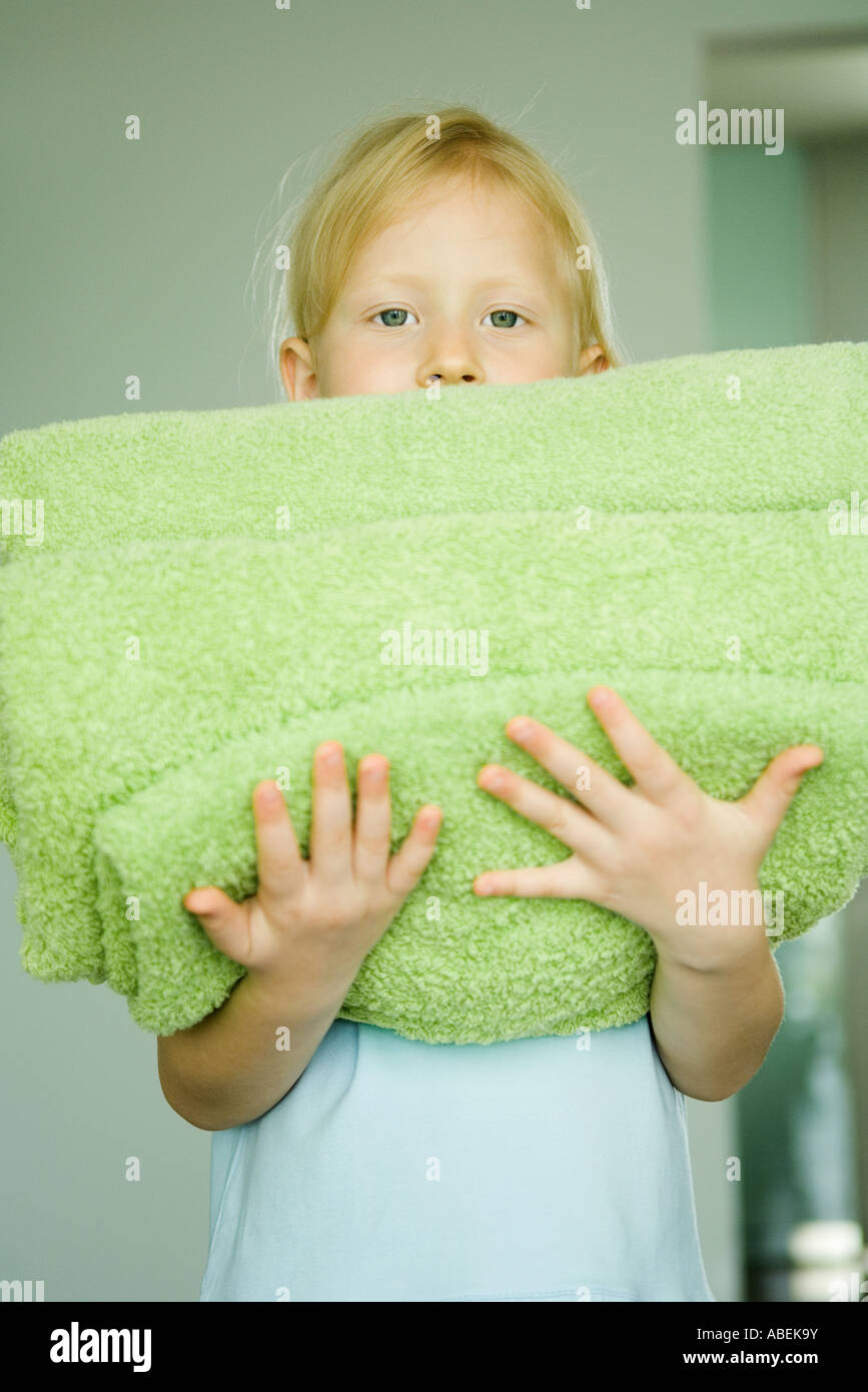 Girl holding stack of folded towels Stock Photo - Alamy