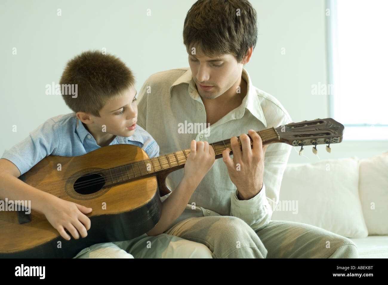 Father and son playing guitar together Stock Photo