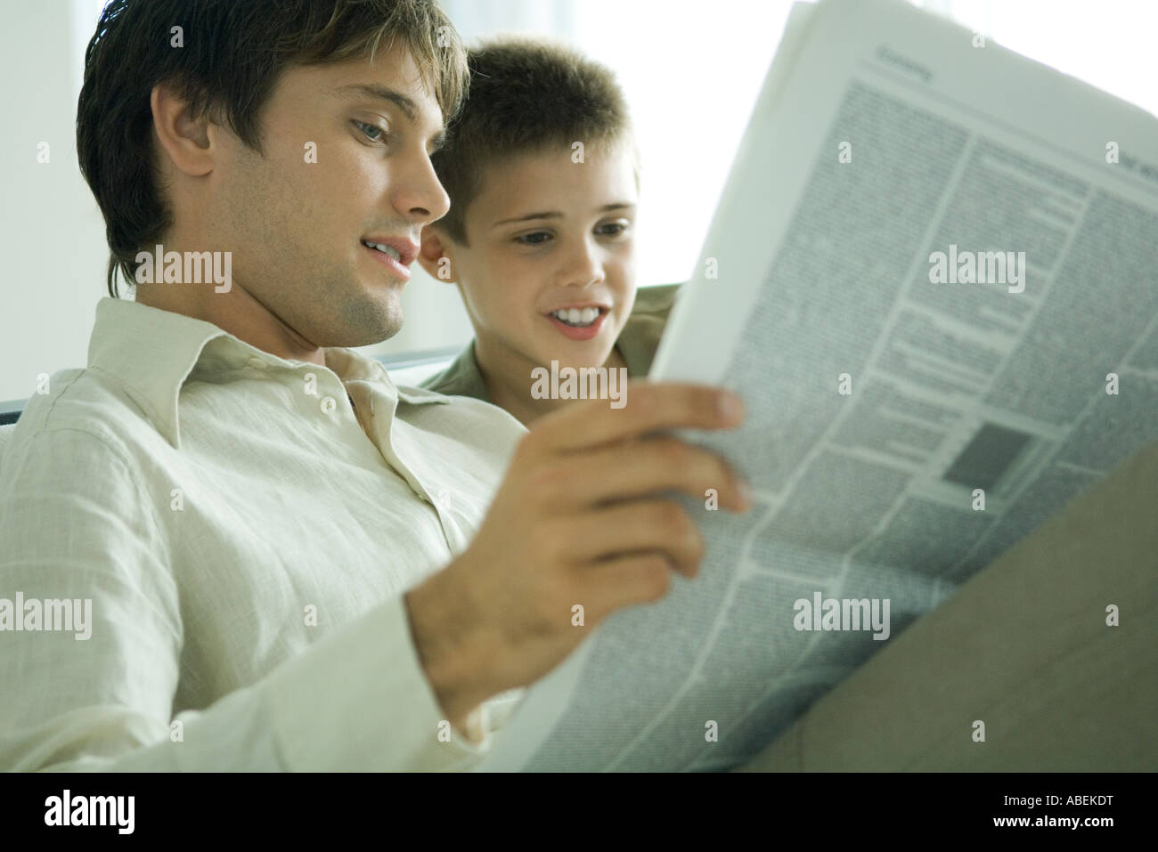 Father and son reading newspaper together Stock Photo