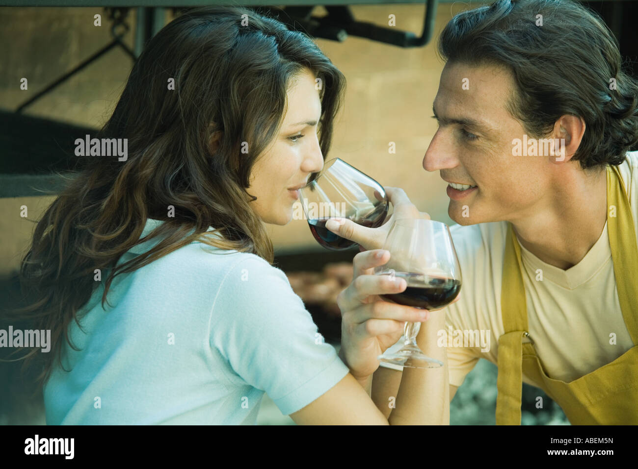 Couple drinking red wine with arms linked Stock Photo Alamy