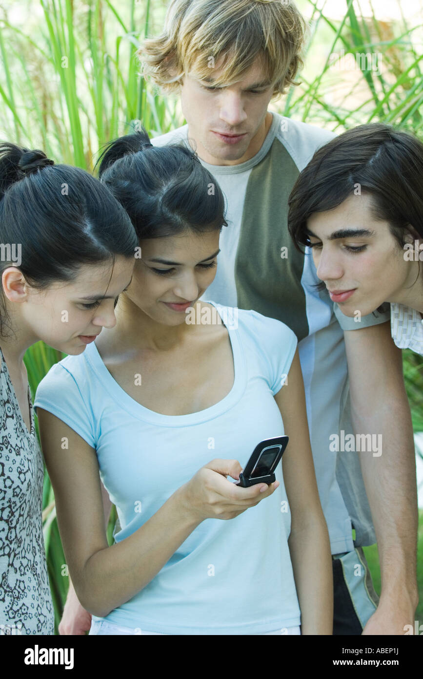 Young friends looking at cell phone together Stock Photo