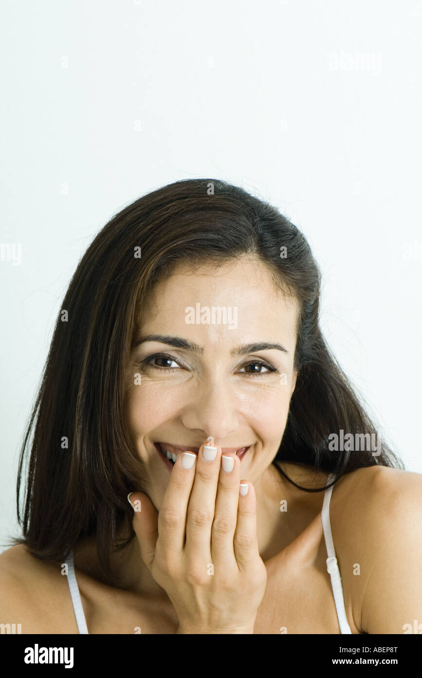 Woman smiling and covering mouth, portrait Stock Photo - Alamy