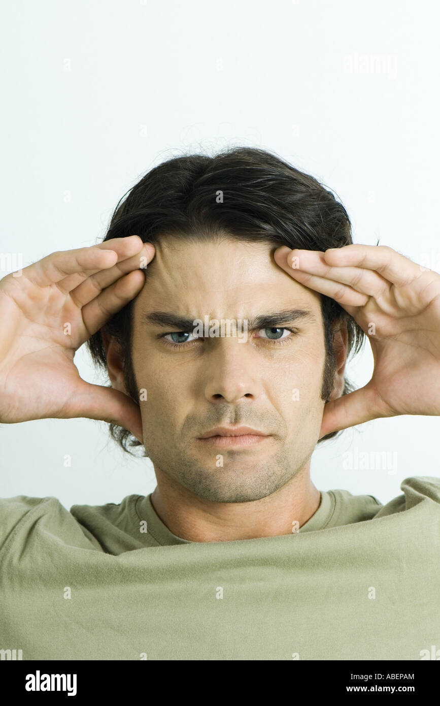 Man holding head, furrowing brow, portrait Stock Photo