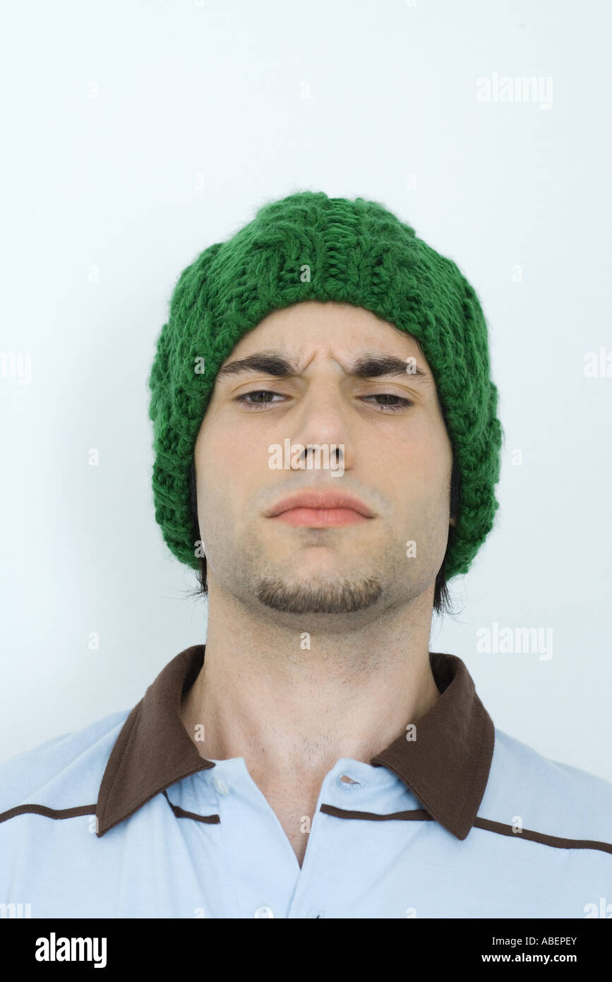 Young man wearing knit hat, furrowing brow, portrait, close-up Stock Photo