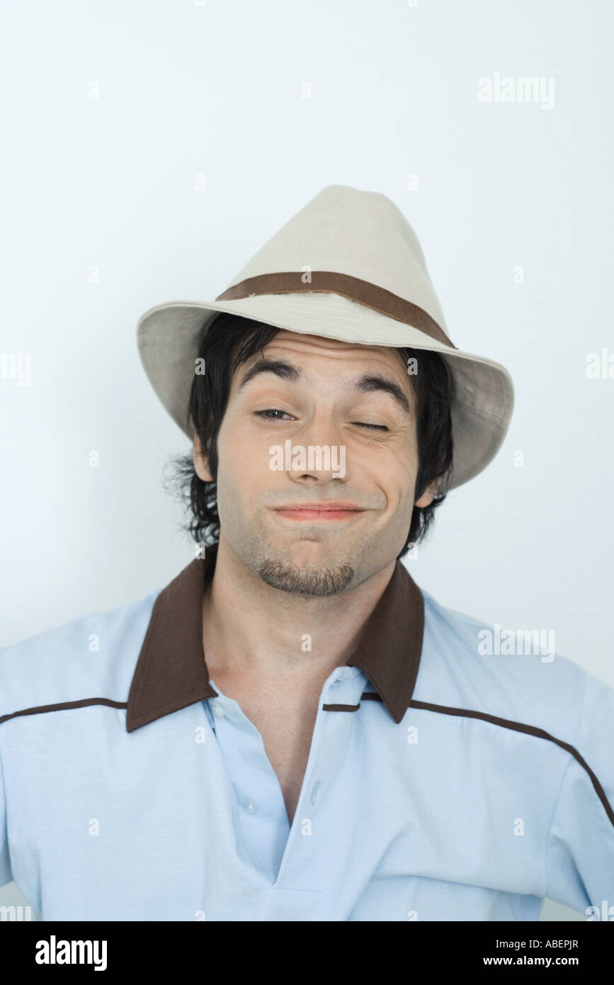 Young man wearing hat, winking at camera, portrait Stock Photo - Alamy