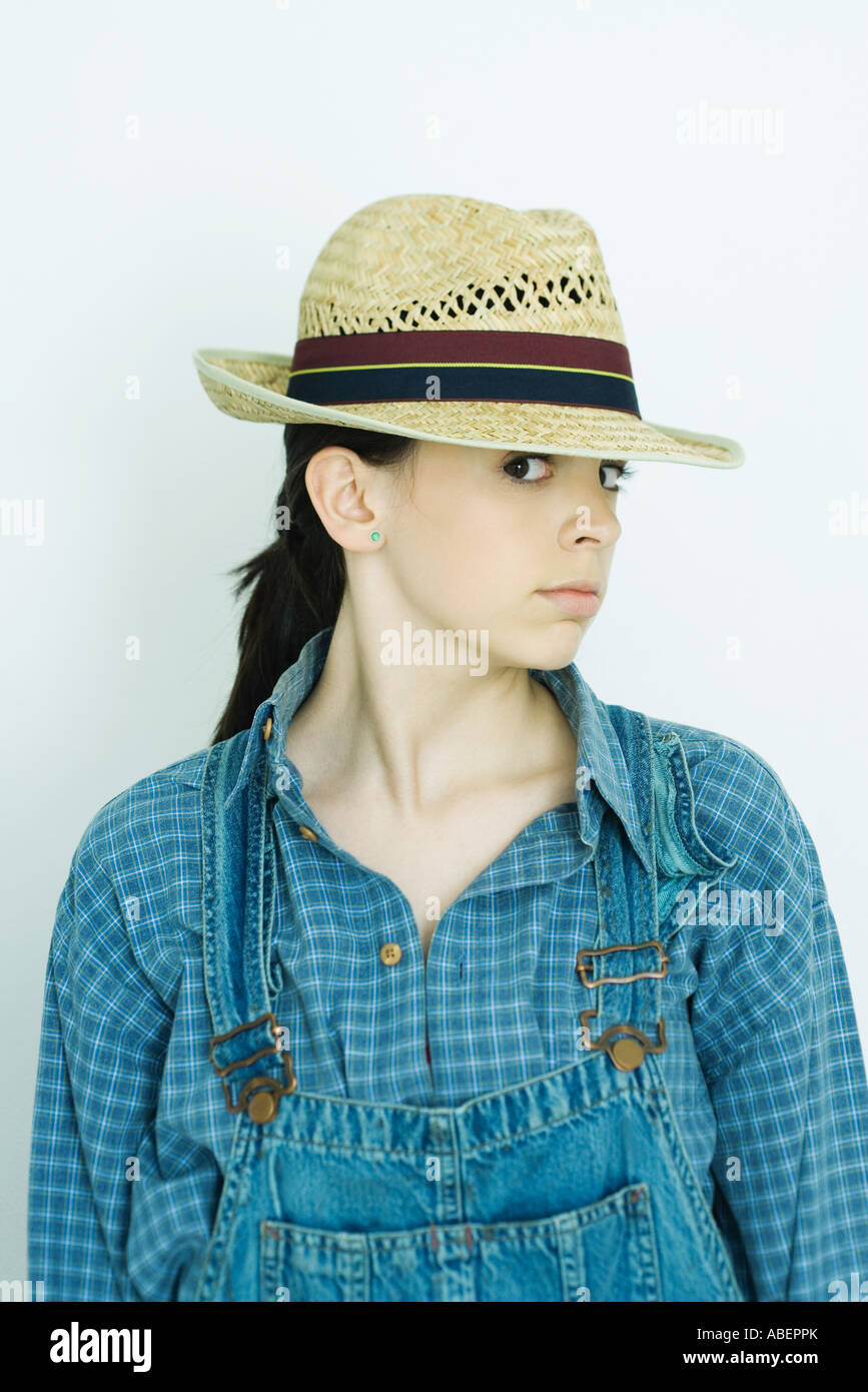 Teen girl wearing overalls and straw hat, portrait Stock Photo Alamy