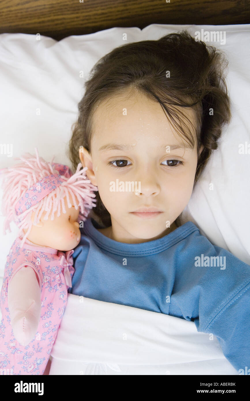 Girl lying in hospital bed Stock Photo