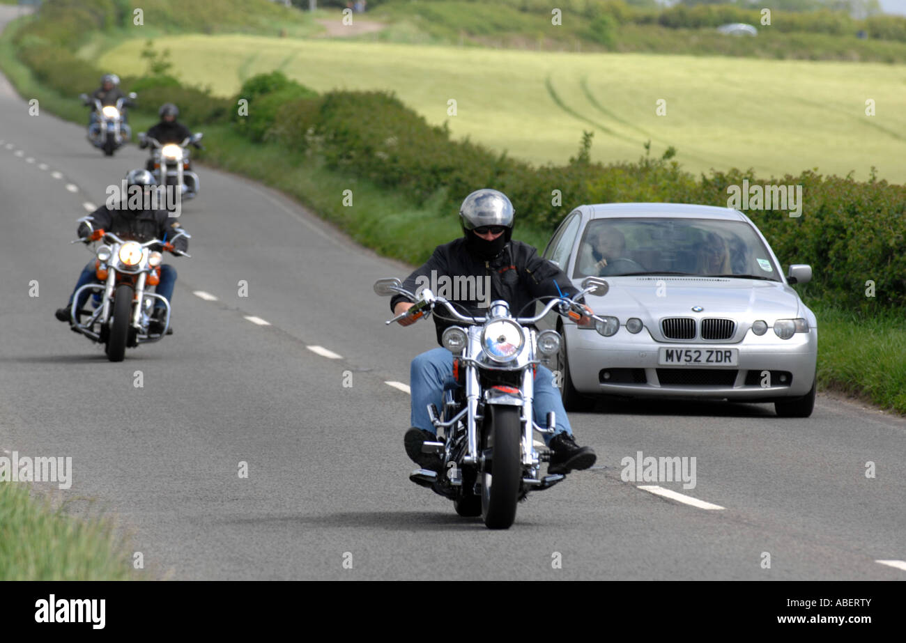 Harley Davidson motorcycles overtaking cars, Britain, UK Stock Photo
