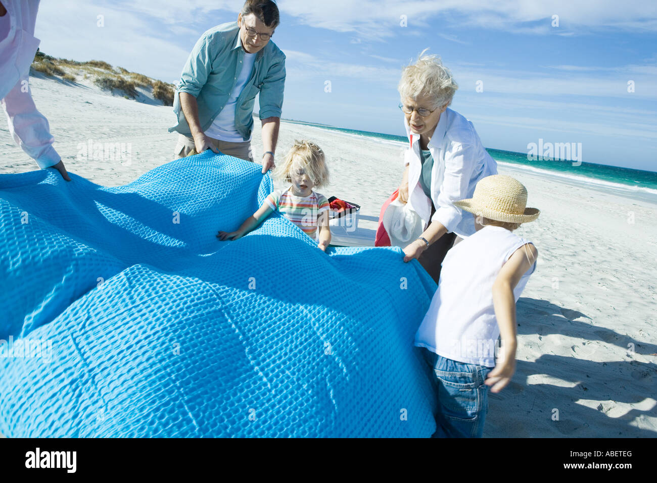 Family on beach spreading blanket hires stock photography and images