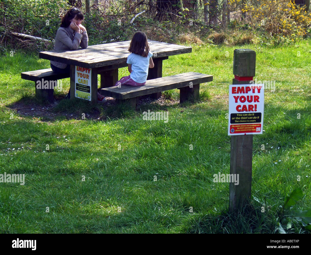 Empty your car warning sign on a post and picnic bench, Dorset Britain, UK Stock Photo