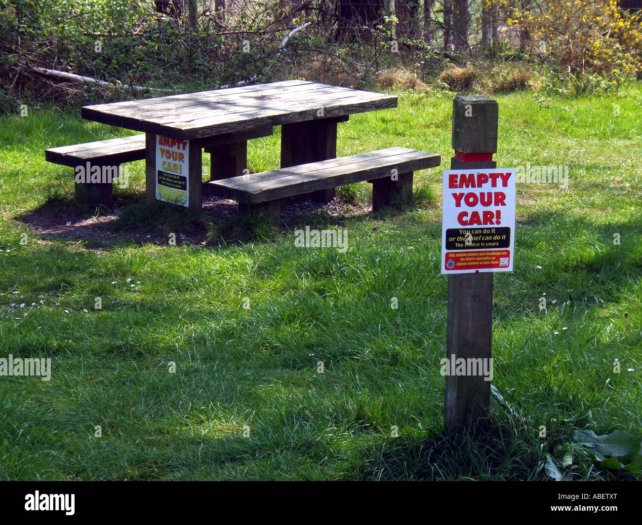Empty your car warning sign on a post and picnic bench, Dorset Britain, UK Stock Photo