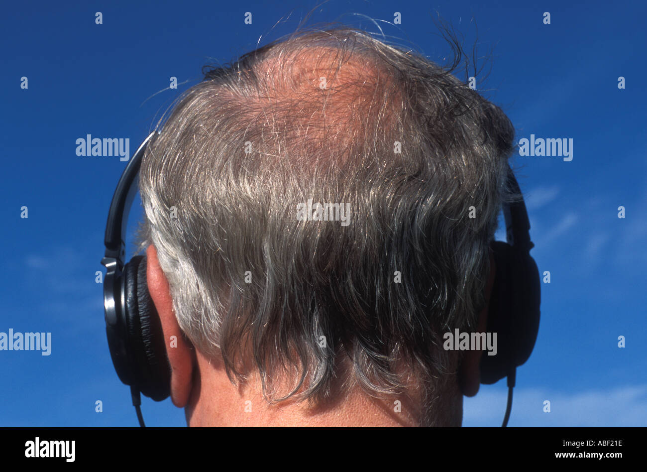 Man with headphones on balding grey head Stock Photo Alamy