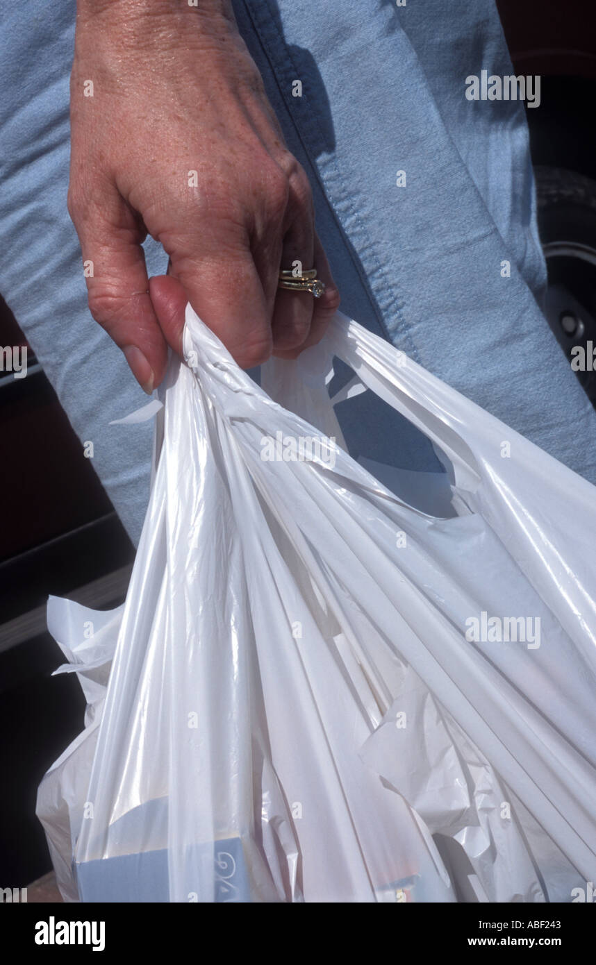 Shoppers carrying plastic shopping bags hires stock photography and