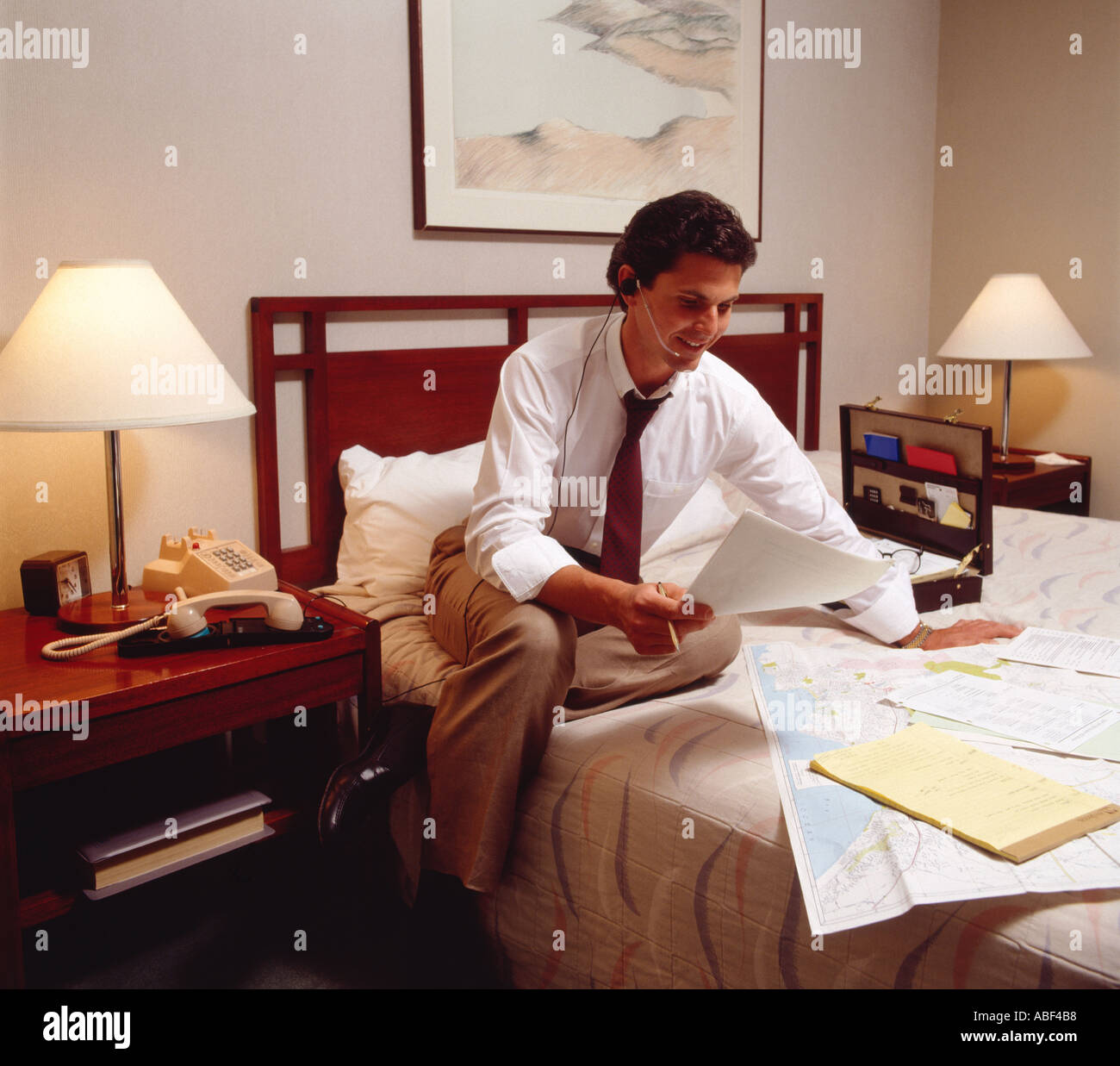 Communications - Business executive in a hotel room uses a telephone ...