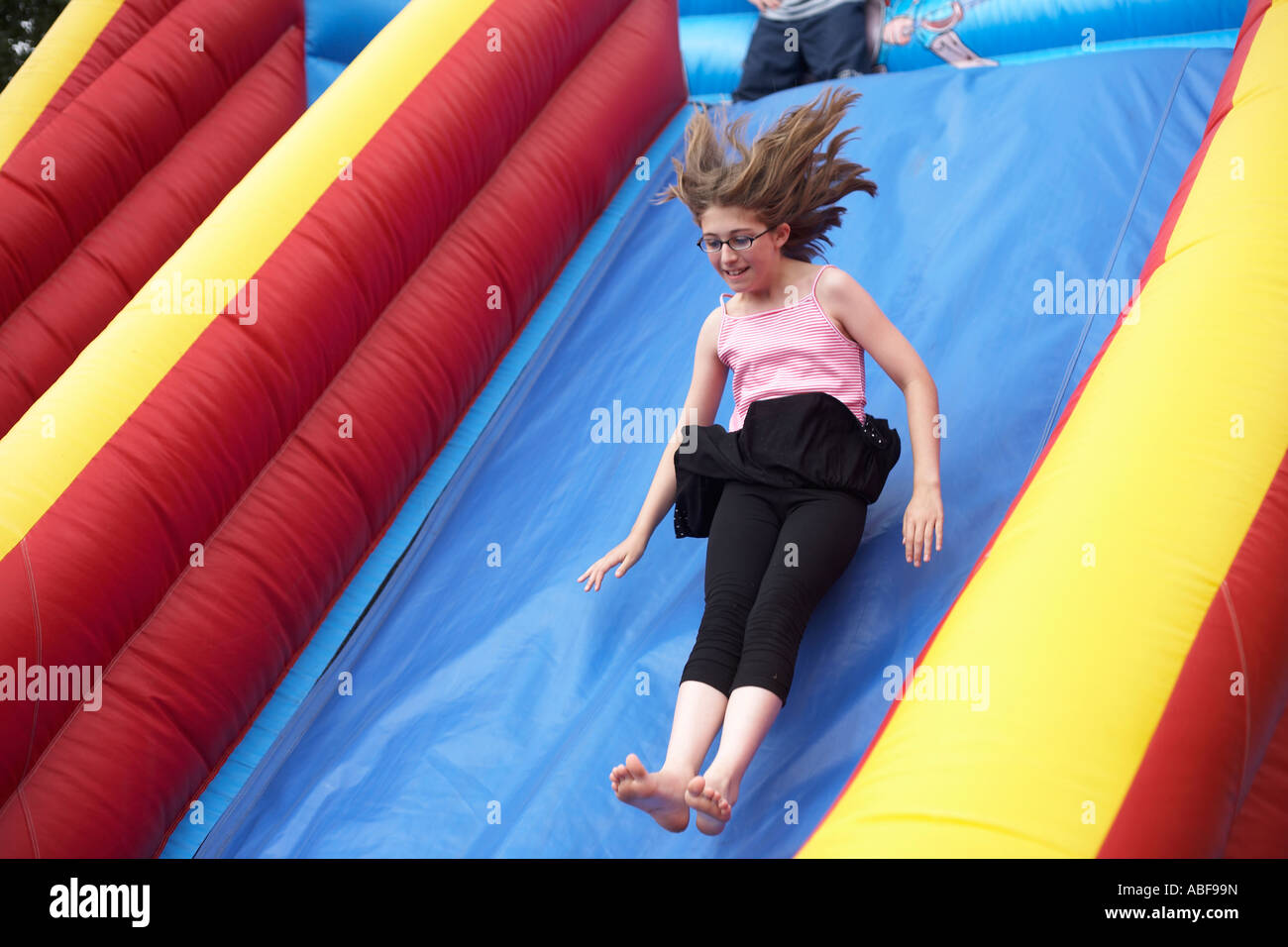An 11 yearold girl with trailing hair, slides fast down a slope on an