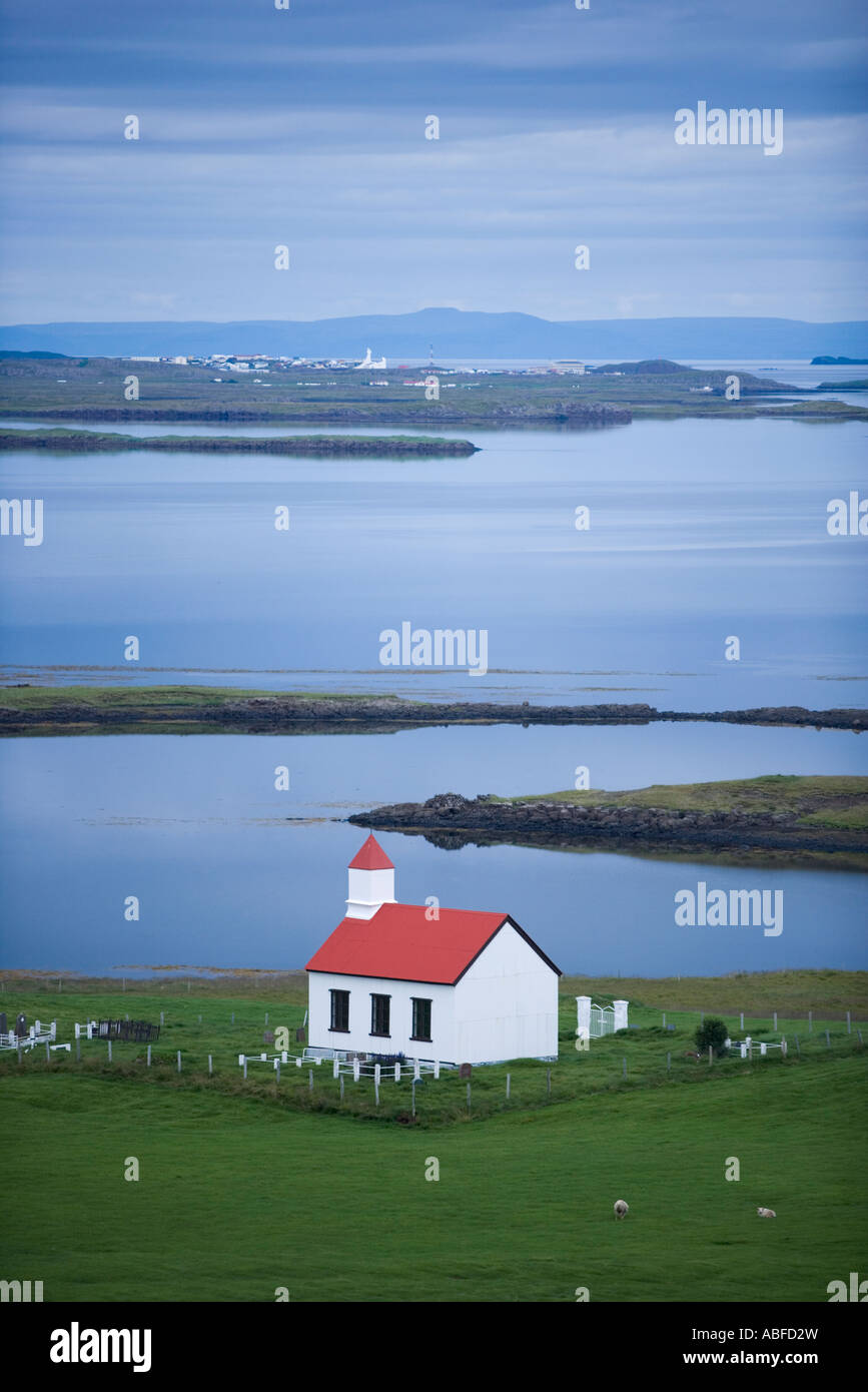 Narfeyri Iceland A church with a red roof sits on the edges of a bay in Narfeyri Stock Photo