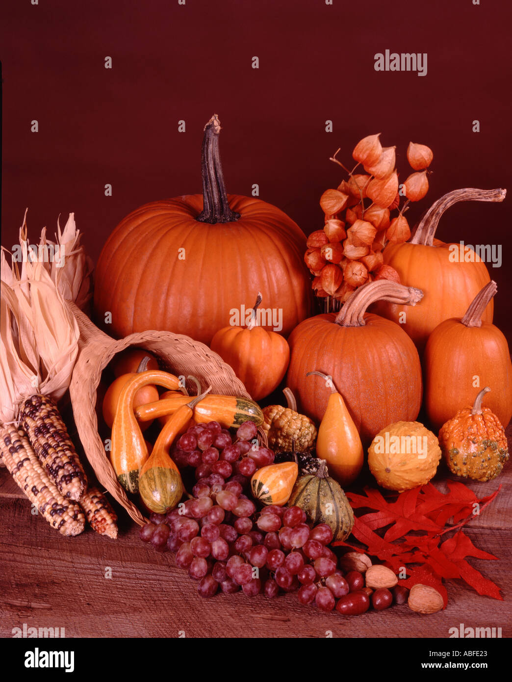 Harvest still life with cornucopia and autumn vegetables against a ...