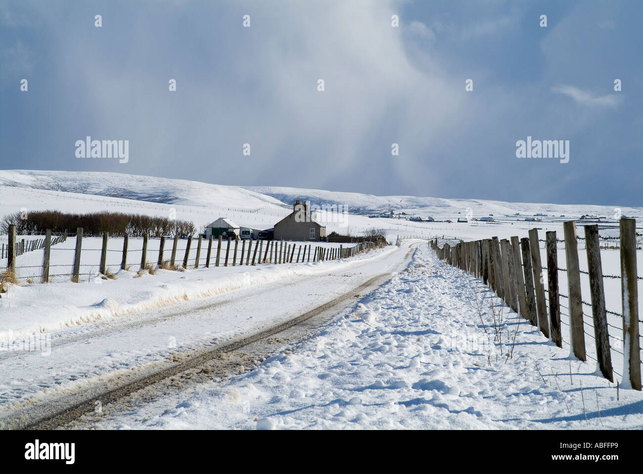 dh Russland HARRAY ORKNEY Cottage on farm roadside grey storm clouds snowscape wintery remote road winter Stock Photo